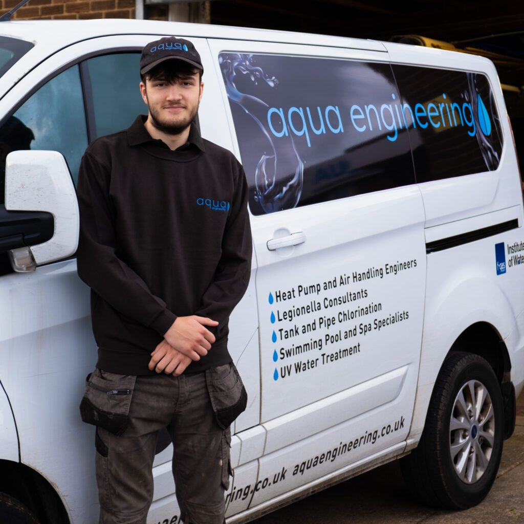 Isaac Mitchell, apprentice swimming pool and water treatment engineer at Aqua Engineering, pictured here beside one of the company vans.