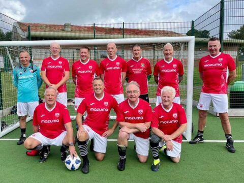 Morecambe's walking football team in front of goal.