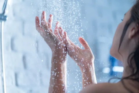 a person is standing in front of a shower with water running down their body