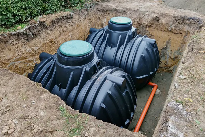 two plastic water tanks sited in the ground next to each other for rainwater harvesting