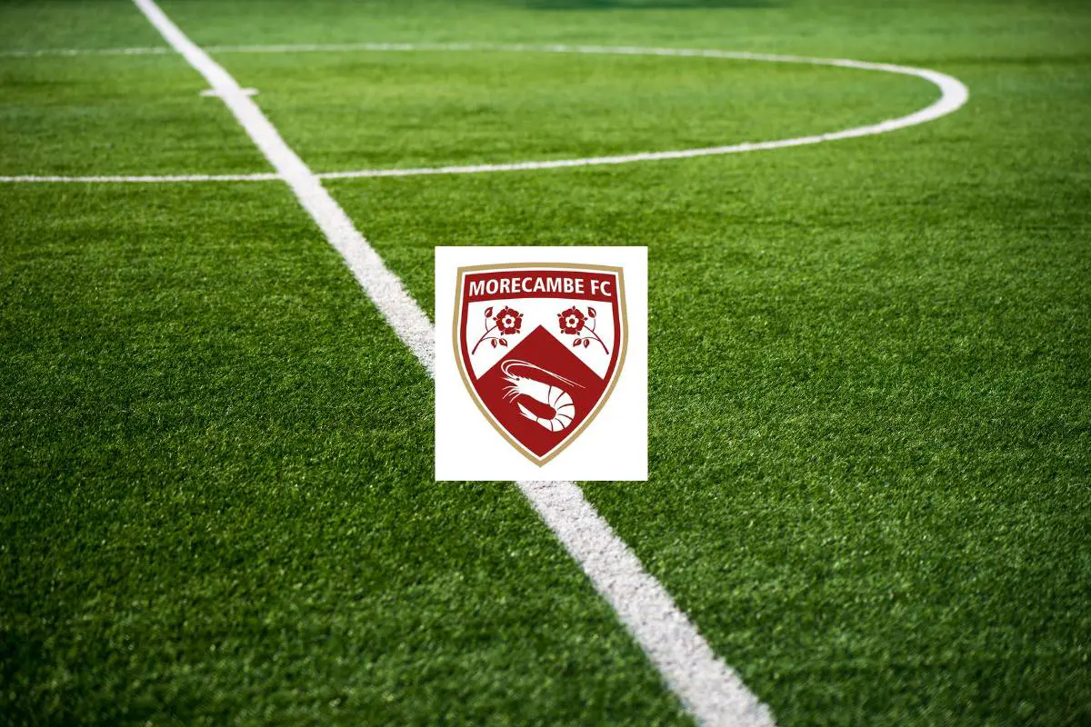 A pristine football pitch overlayed with the badge for Morecambe FC