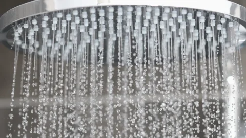 Deluge shower head with water cascading in a shower - a potential hotspot for legionella bacteria
